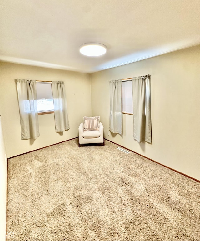 unfurnished room featuring carpet, visible vents, and baseboards