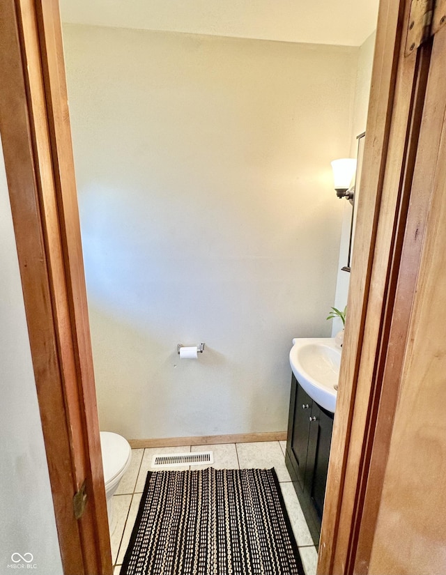 bathroom with visible vents, baseboards, toilet, tile patterned floors, and vanity