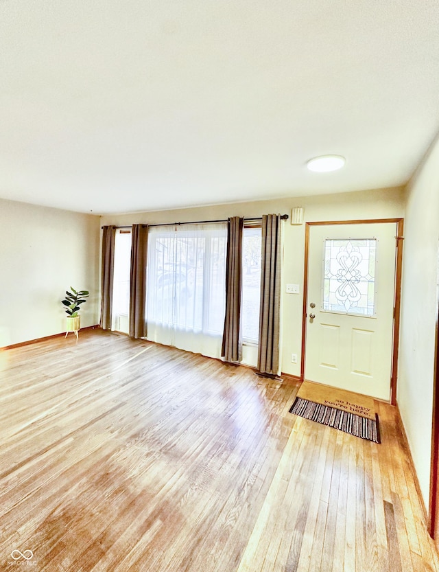 foyer featuring baseboards and light wood-type flooring