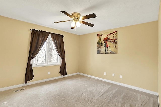 unfurnished room featuring visible vents, ceiling fan, baseboards, carpet, and a textured ceiling