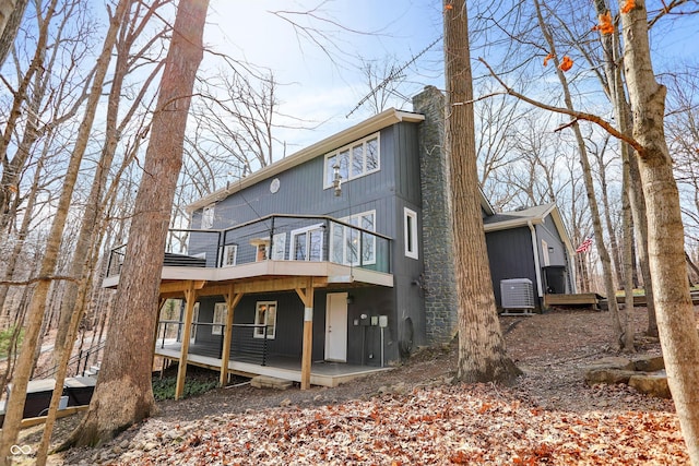 back of property with a wooden deck and a chimney