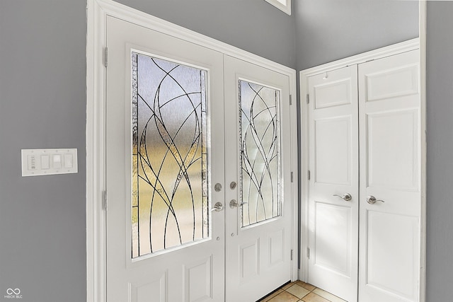 foyer featuring light tile patterned flooring and french doors