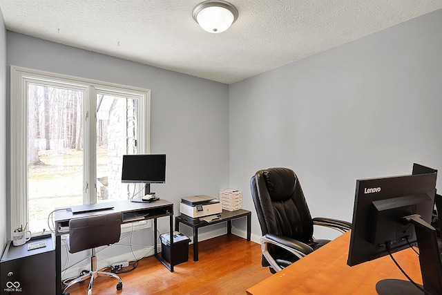 home office featuring baseboards, a textured ceiling, and wood finished floors