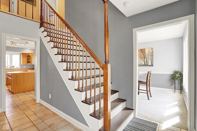 staircase featuring tile patterned flooring, carpet flooring, and baseboards