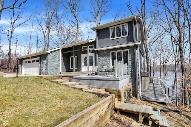 view of front facade with a garage, stone siding, and a front lawn