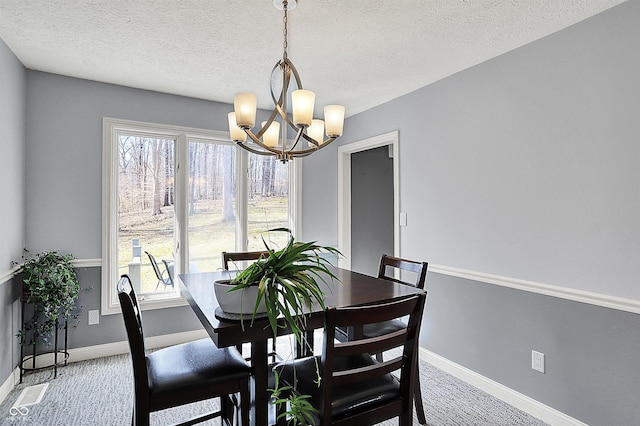 dining room featuring a textured ceiling, baseboards, and an inviting chandelier