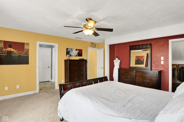 carpeted bedroom featuring baseboards, visible vents, a textured ceiling, and ceiling fan