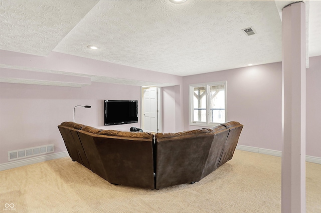 living room with light colored carpet, baseboards, visible vents, and a textured ceiling