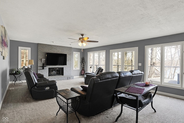 carpeted living room featuring a wealth of natural light, a fireplace, baseboards, and ceiling fan