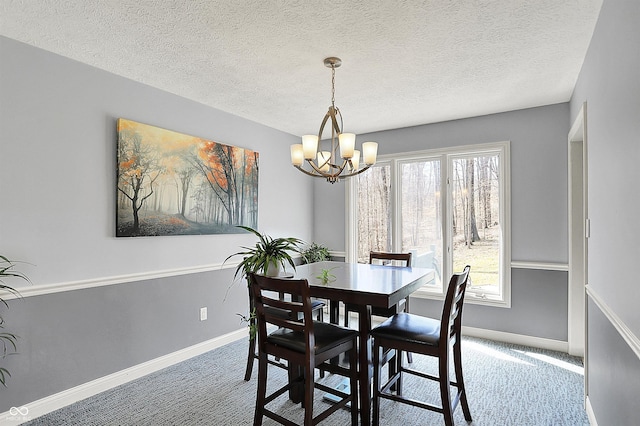 carpeted dining room with a notable chandelier, plenty of natural light, and baseboards