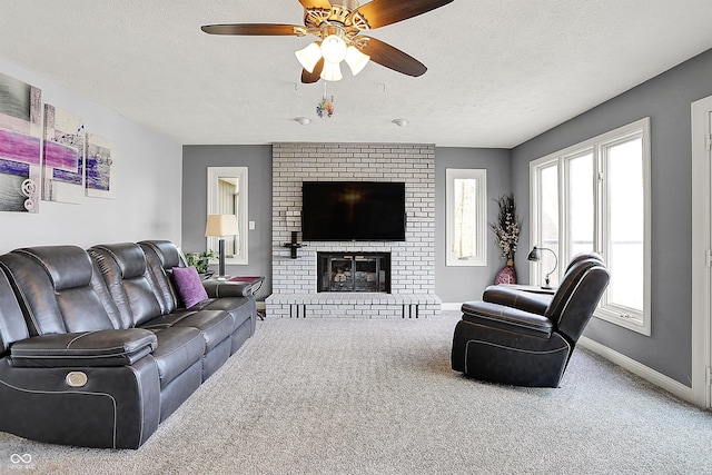 carpeted living area with a fireplace, a ceiling fan, baseboards, and a textured ceiling