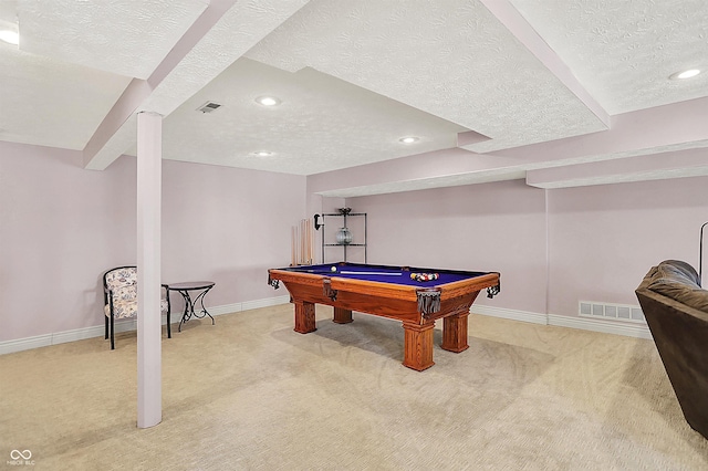 recreation room with visible vents, baseboards, light colored carpet, and a textured ceiling