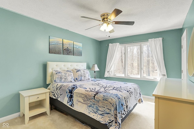 carpeted bedroom featuring ceiling fan, baseboards, and a textured ceiling