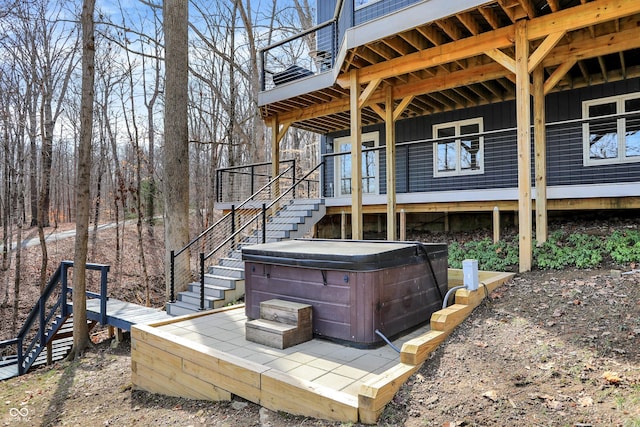 deck with stairs and a hot tub