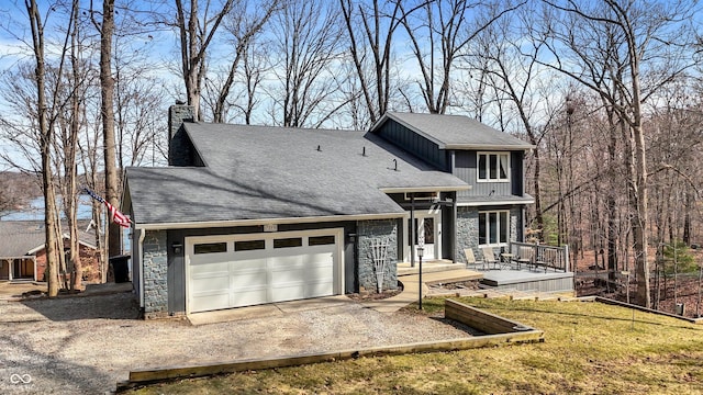 view of front of house featuring driveway, a shingled roof, a chimney, a garage, and stone siding