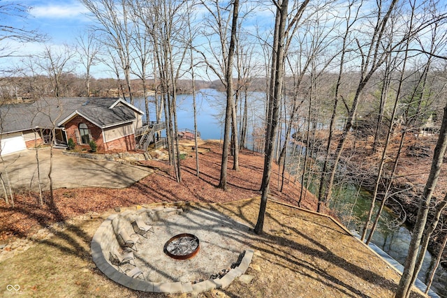 view of yard featuring a water view and an outdoor fire pit