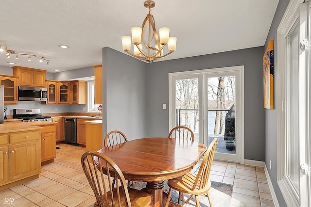 dining room featuring light tile patterned flooring, a notable chandelier, and baseboards