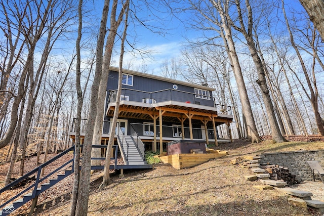 back of property with a wooden deck and stairs