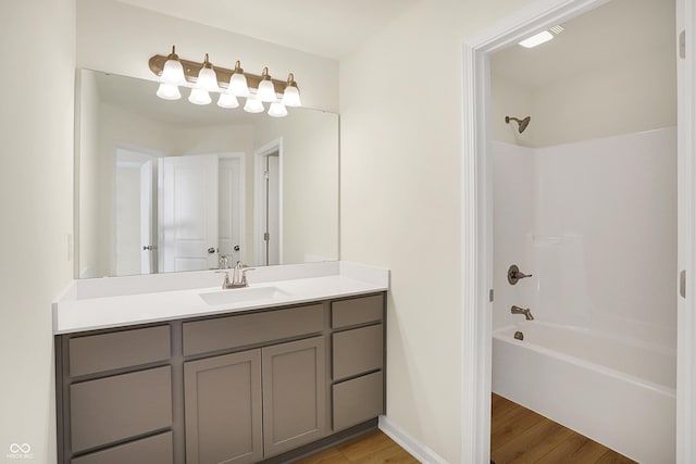 bathroom featuring shower / bath combination, baseboards, wood finished floors, and vanity