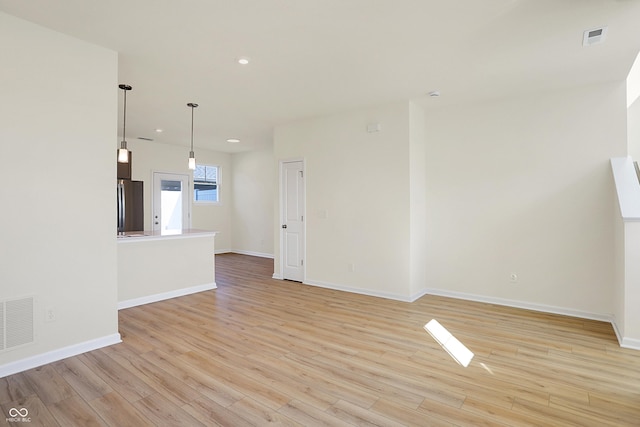 unfurnished living room with recessed lighting, visible vents, baseboards, and light wood finished floors