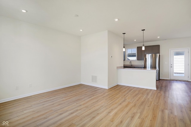 unfurnished living room featuring a wealth of natural light, visible vents, recessed lighting, and light wood-type flooring