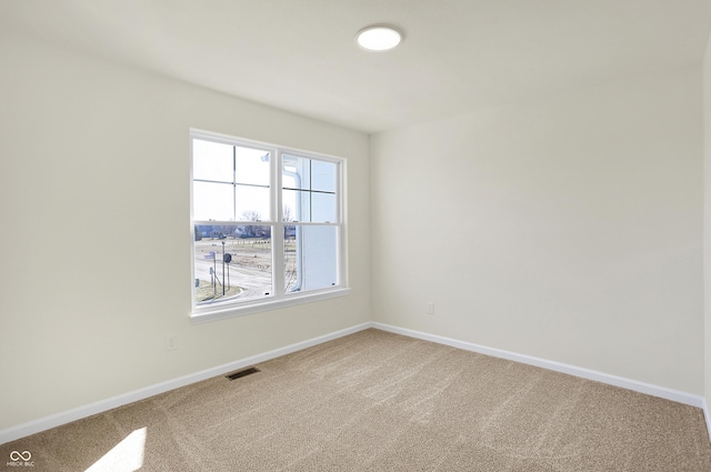 spare room featuring carpet flooring and baseboards