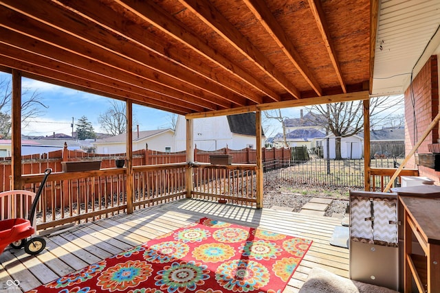 view of patio / terrace with a deck, an outdoor structure, a storage unit, and a fenced backyard