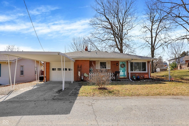 view of front of property featuring brick siding, a front lawn, driveway, a carport, and an attached garage