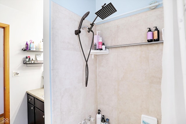 full bathroom with tiled shower and vanity