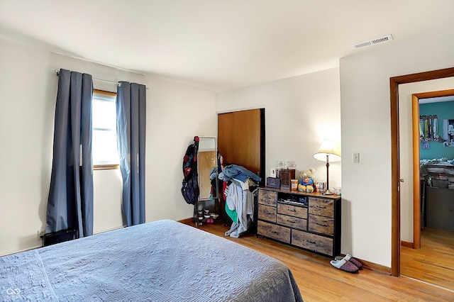 bedroom featuring visible vents, baseboards, and light wood-style floors