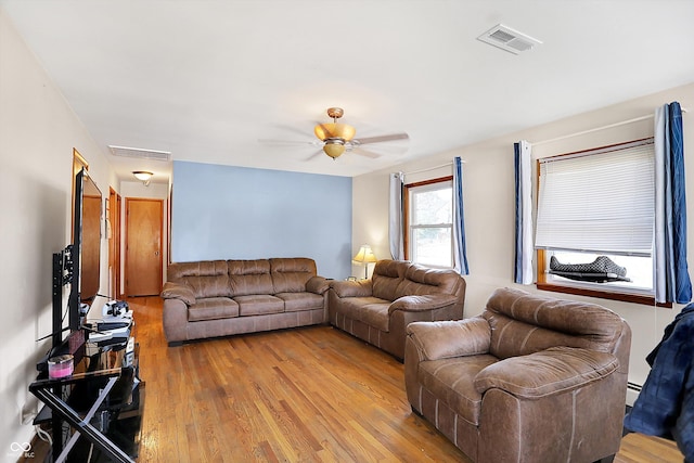 living room featuring ceiling fan, visible vents, light wood-style flooring, and a baseboard radiator