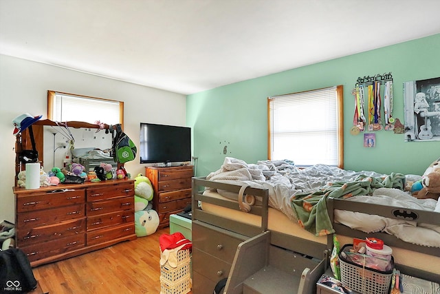 bedroom featuring multiple windows and light wood-style floors