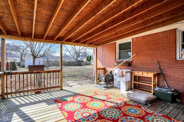 deck featuring a shed, an outdoor structure, and fence