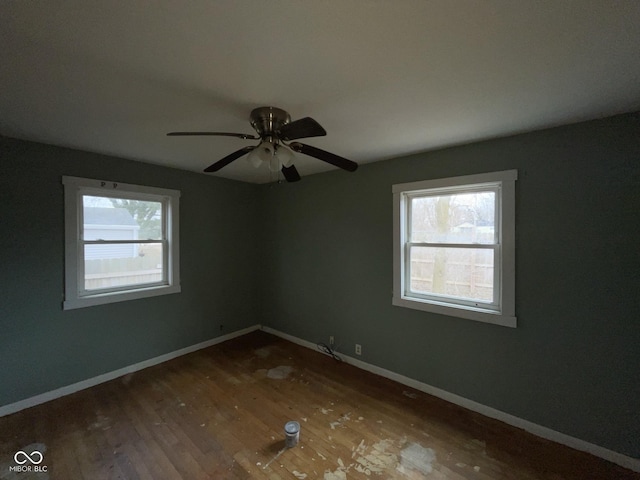 spare room featuring wood finished floors, baseboards, and ceiling fan