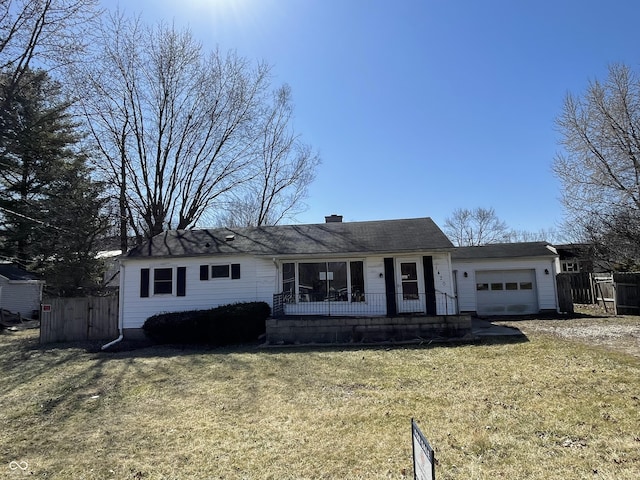 ranch-style home featuring a front yard, a porch, an attached garage, and fence