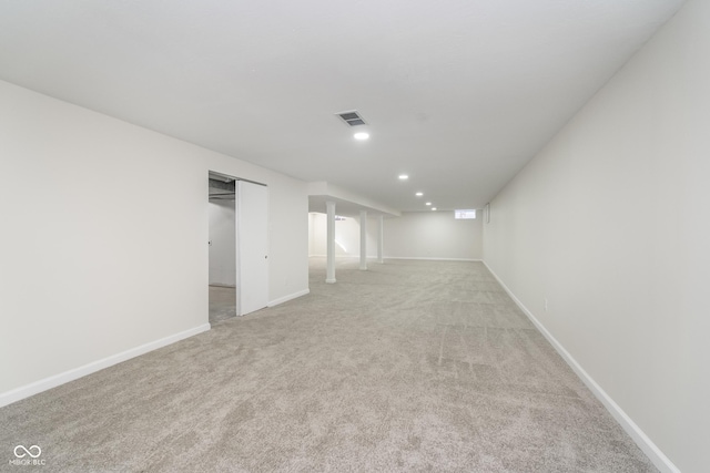 spare room with light colored carpet, recessed lighting, visible vents, and baseboards