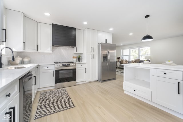 kitchen with light wood-style flooring, a sink, stainless steel appliances, custom range hood, and white cabinets