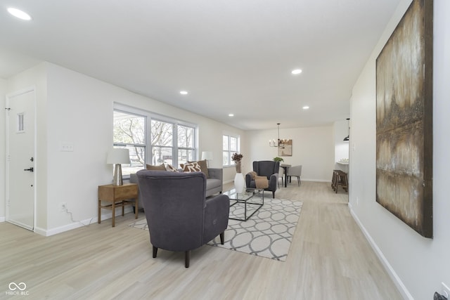 living room featuring recessed lighting, baseboards, and light wood-style floors