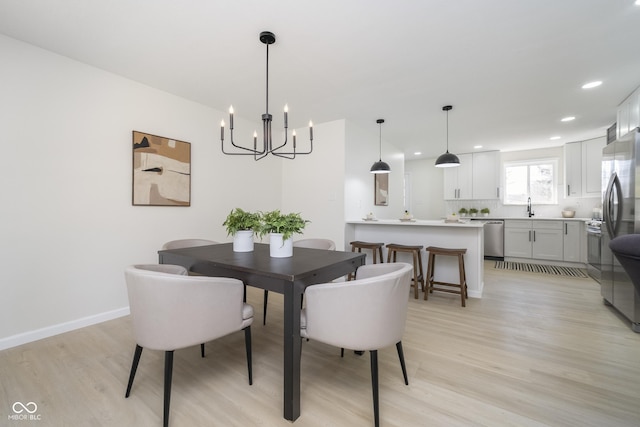 dining room with recessed lighting, baseboards, a chandelier, and light wood finished floors