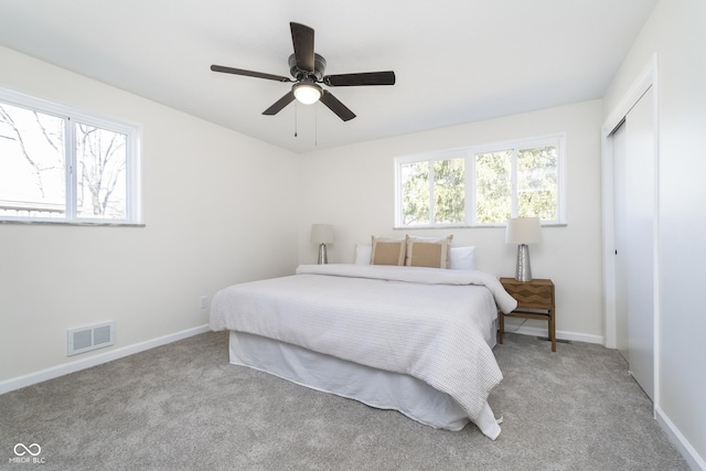 carpeted bedroom featuring a closet, visible vents, ceiling fan, and baseboards