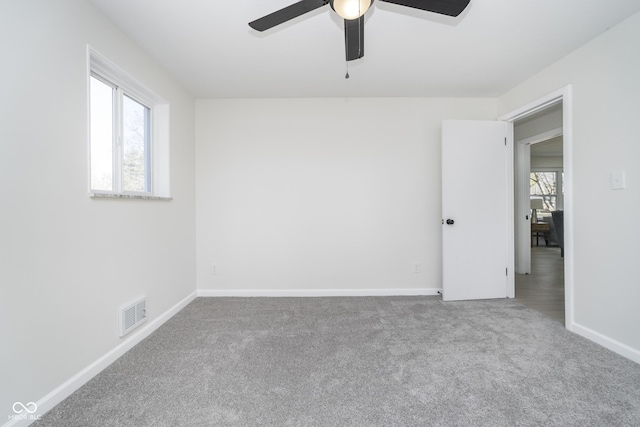 unfurnished room featuring visible vents, a healthy amount of sunlight, ceiling fan, and carpet floors