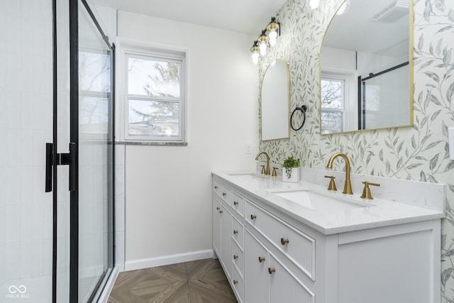 full bath with wallpapered walls, baseboards, a stall shower, and a sink