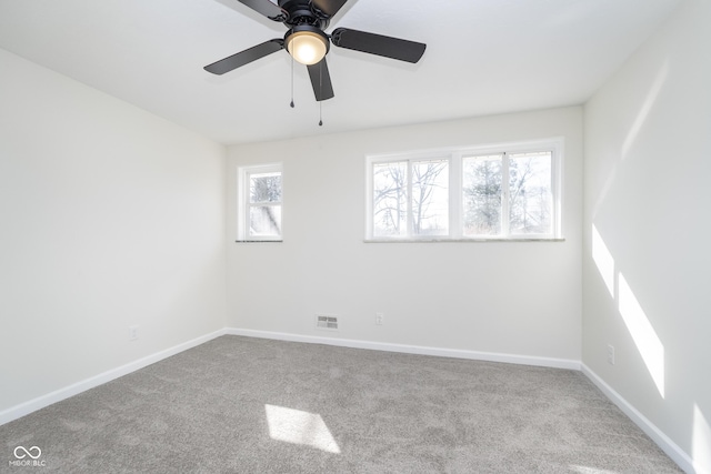 carpeted empty room with a ceiling fan, baseboards, and visible vents