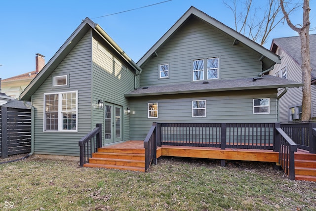 back of property with a yard and a wooden deck