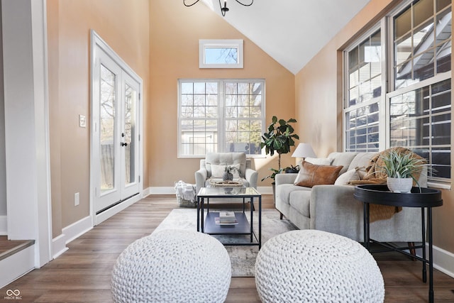 living area with baseboards, high vaulted ceiling, and dark wood-style flooring