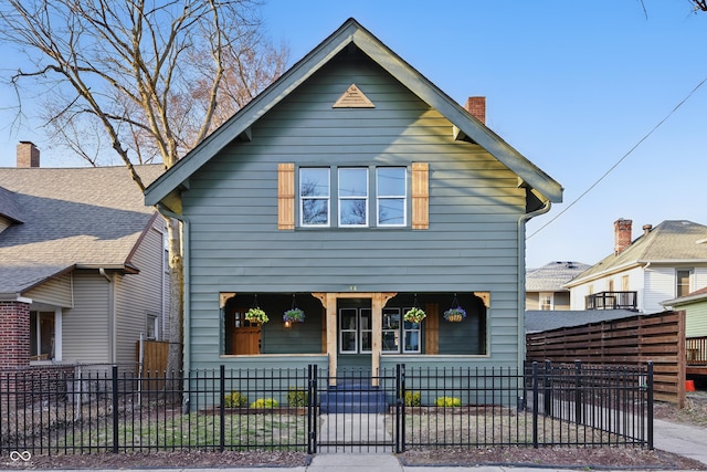 view of front of house with a fenced front yard, covered porch, and a chimney