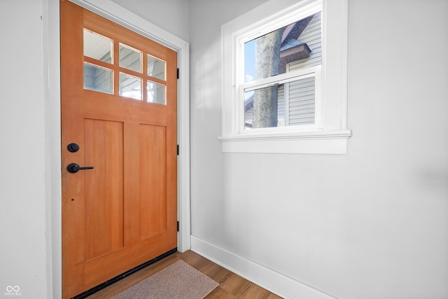 doorway with baseboards and wood finished floors