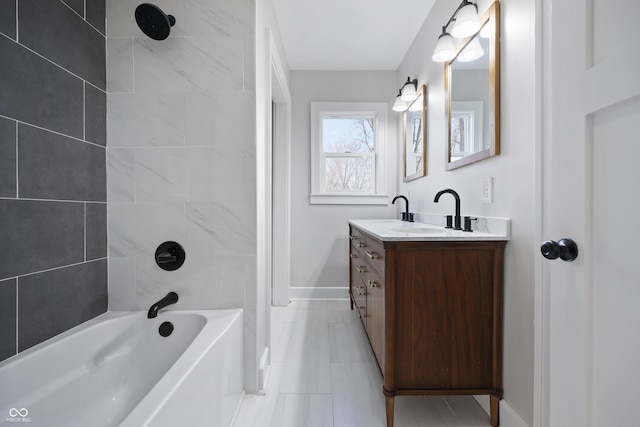 full bathroom with a sink, baseboards, shower / tub combination, and double vanity