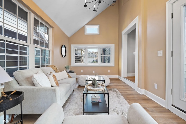 living room with baseboards, high vaulted ceiling, and wood finished floors