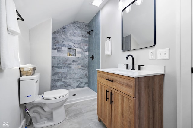 full bathroom with tiled shower, toilet, vanity, and lofted ceiling